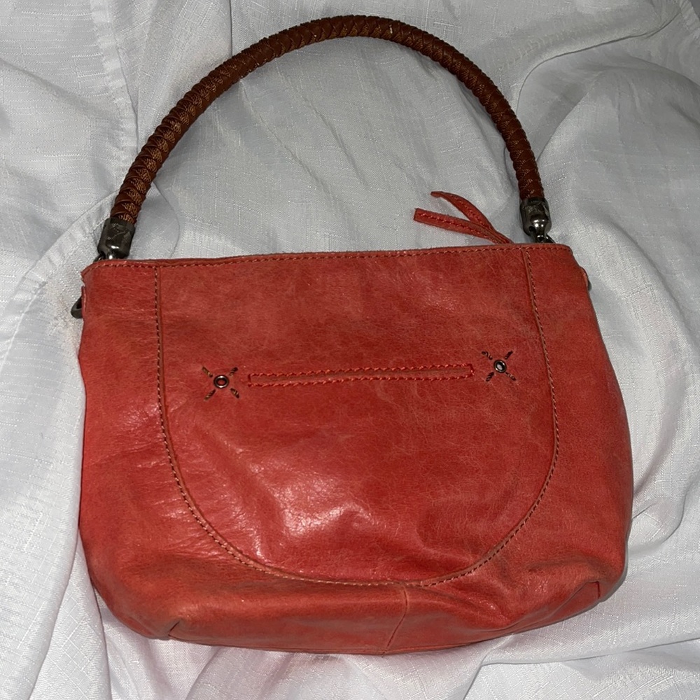 The Sak coral color with brown braided handle shoulder bag